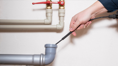 Plumber cleaning a drain