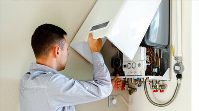 Plumber performing a home inspection of a tankless water heater